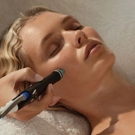 Woman receiving a facial treatment with a device on her face.