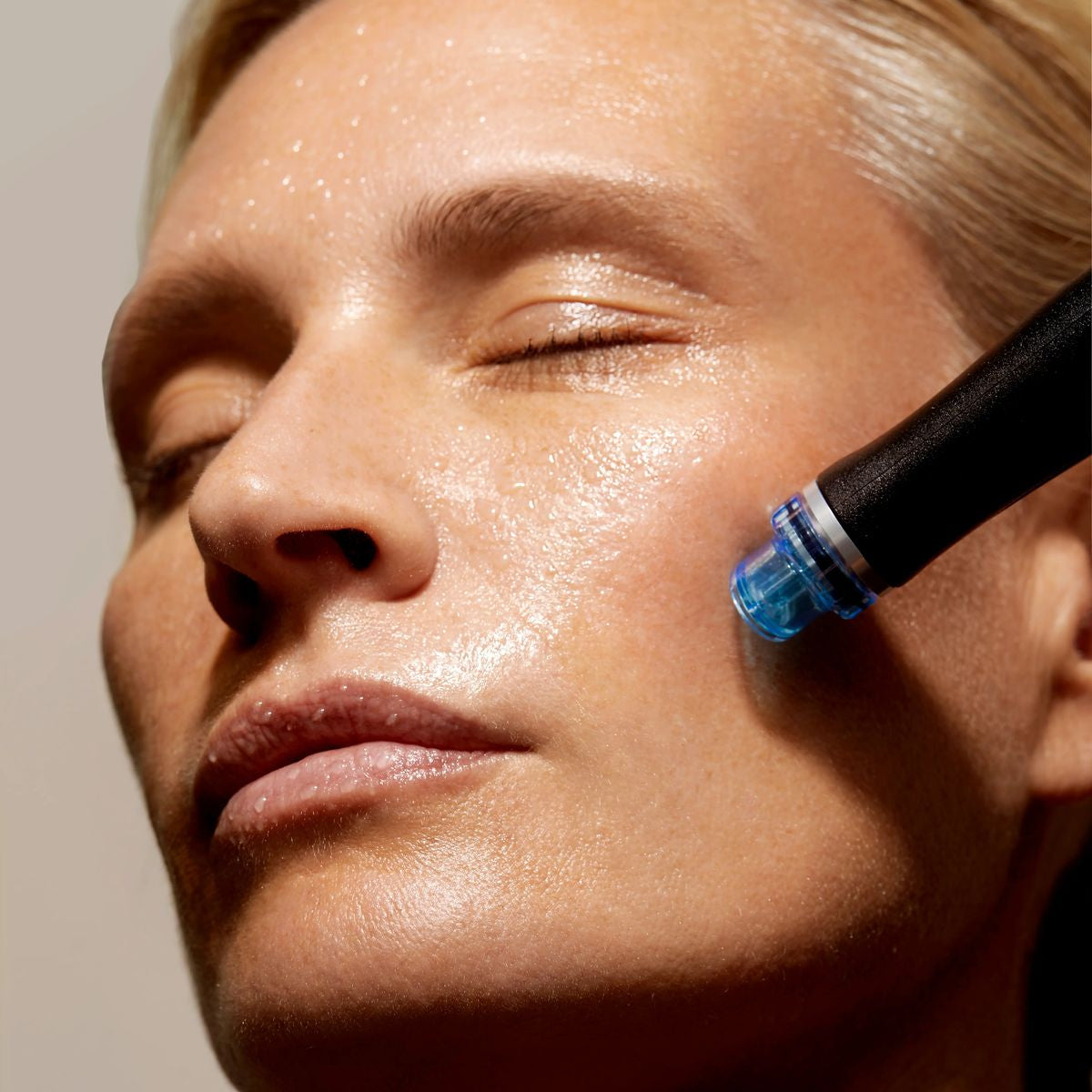 Close-up of a person using a skincare device on their face.