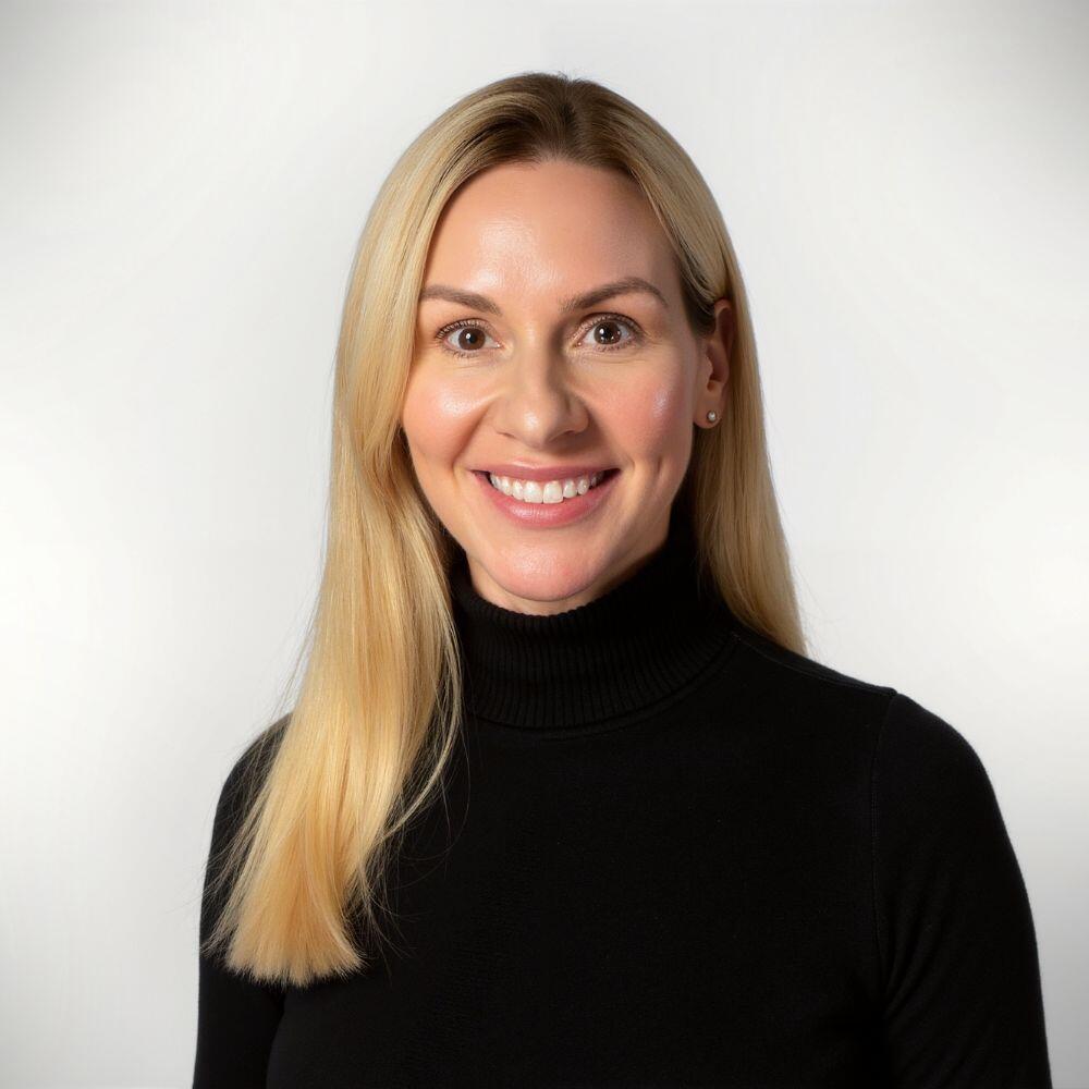 Woman with blonde hair wearing a black turtleneck against a white background