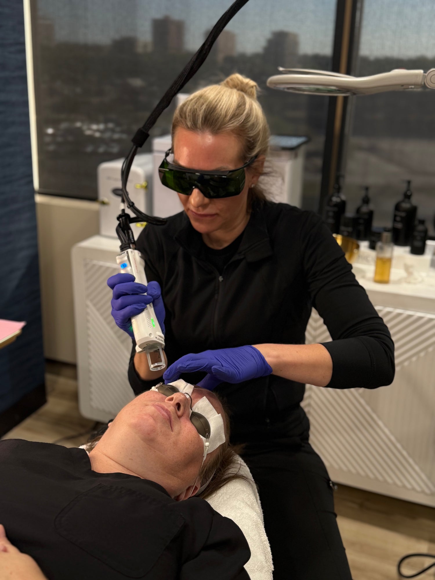 Person receiving a laser treatment from a professional in a clinical setting.