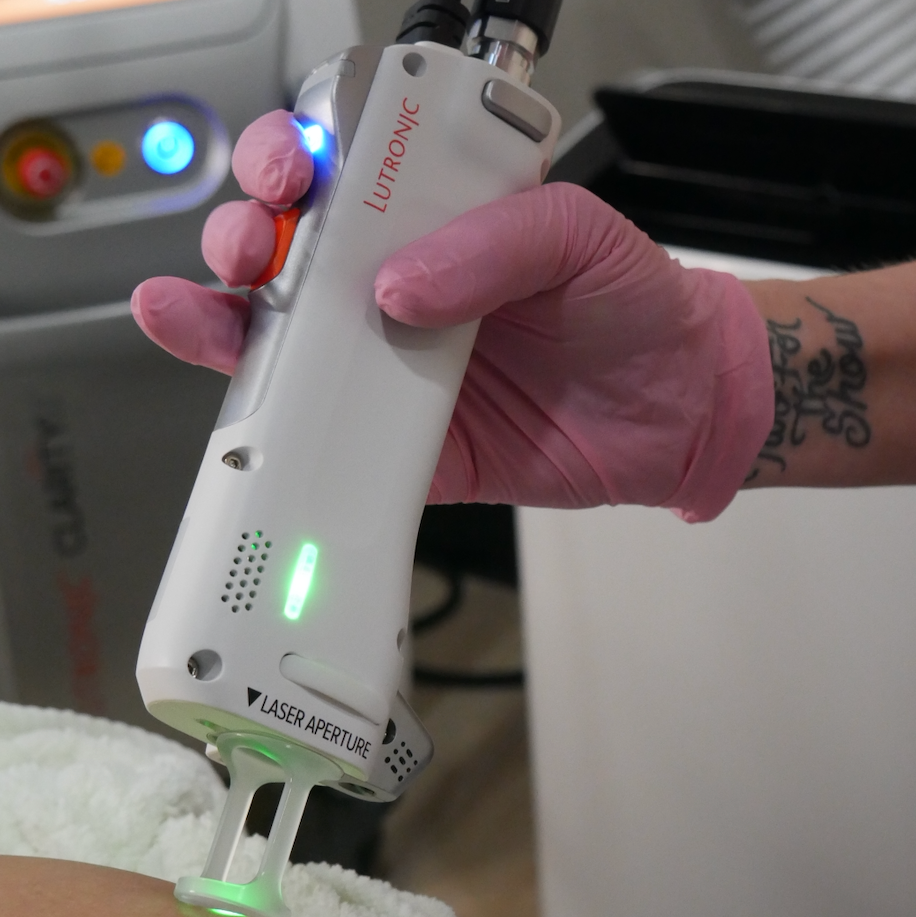 Person wearing gloves holding a laser device on a medical setting