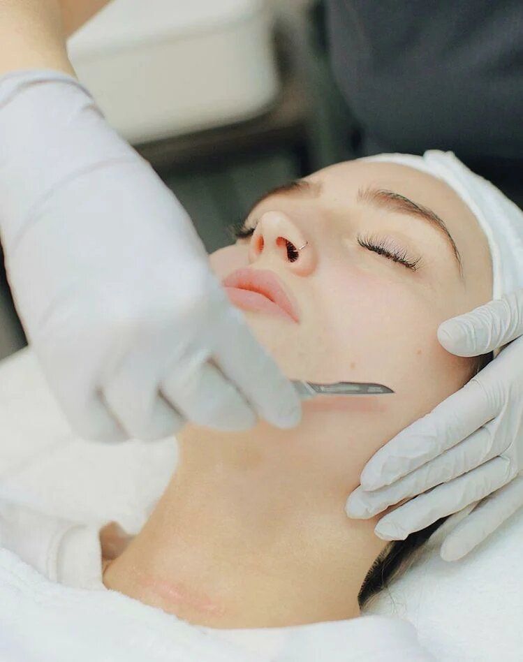 Person receiving a facial treatment with gloved hands